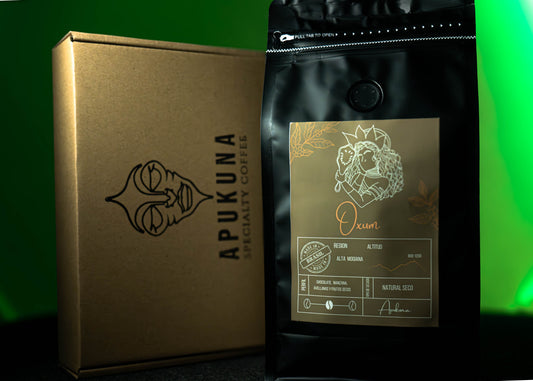 Bolsa de café de especialidad Oxum de Apukuna Coffee junto a caja de cartón con logotipo. Café brasileño de la región Alta Mogiana, con empaque elegante en fondo verde.
